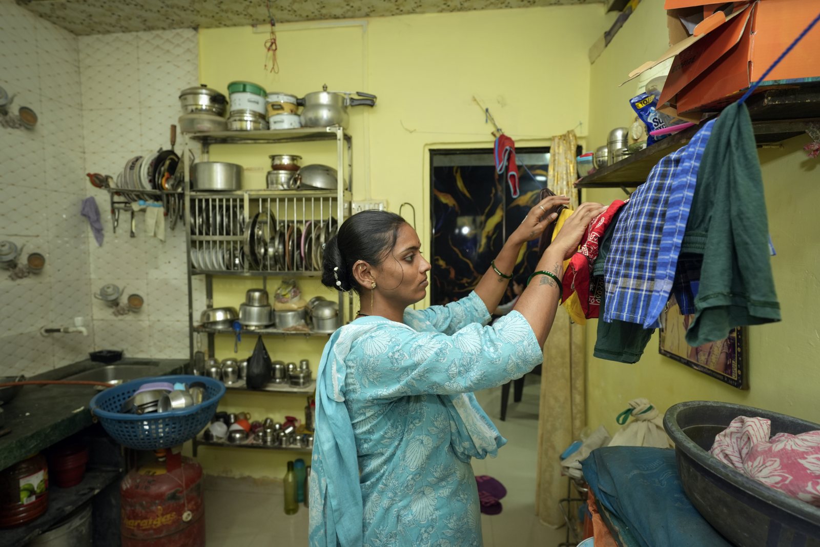 Kavita Deepak Kshirsagar hanging clothes to dry in her kitchen in Ulhasnagar